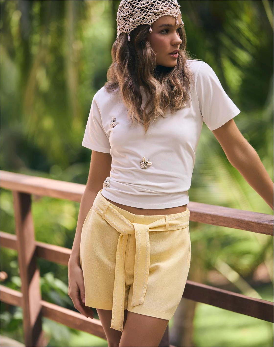 Mujer con camiseta blanca y short amarillo, ropa casual fresca para clima cálido.
