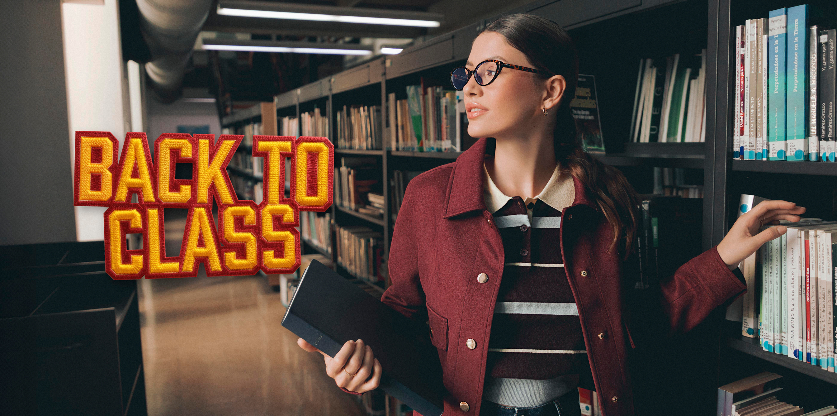 Mujer en biblioteca usando chaqueta vino, polo a rayas y jeans; outfit back to school cómodo y elegante para clases y universidad.