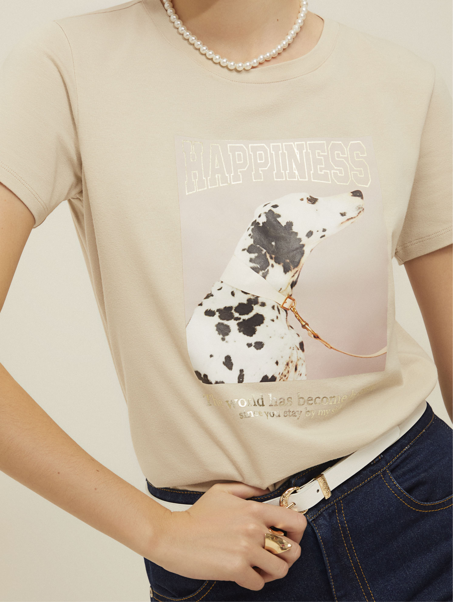 Modelo vistiendo camiseta básica beige con estampado de dálmata de la marca ELA