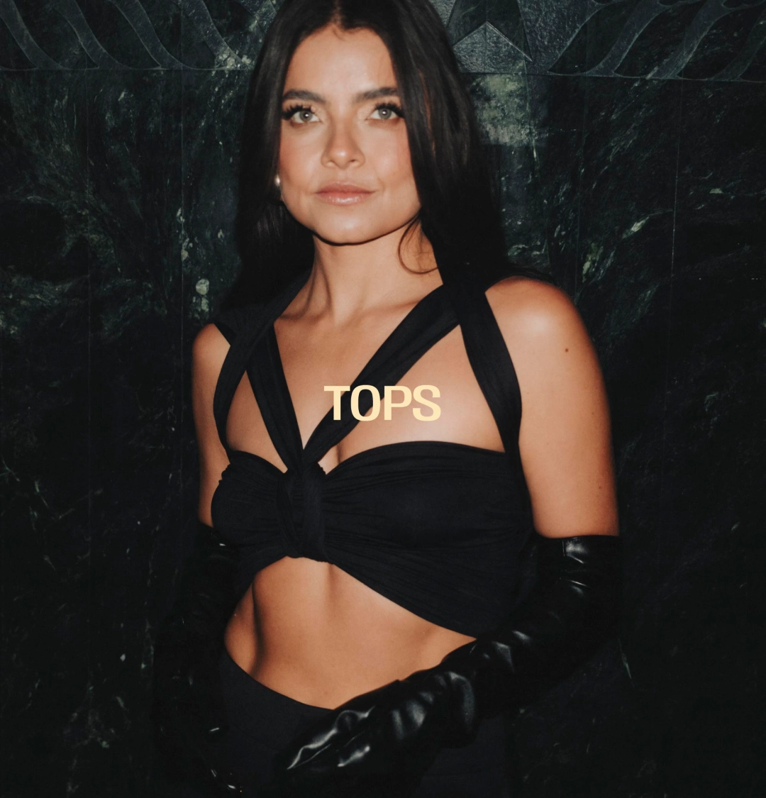 Mujer con top, pantalón negro y guantes largos.
