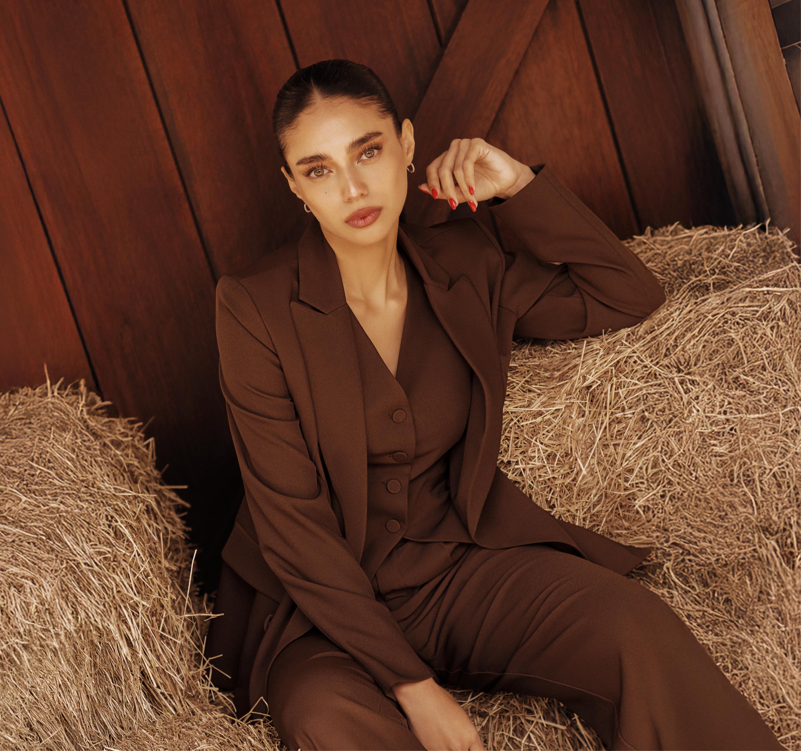 Mujer vistiendo traje marrón de la colección fall 2025, estilo elegante y moderno inspirado en tendencias de moda colombiana.